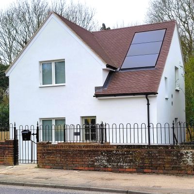 Elvis House A newly refurbished white rendered house, with brown roof and black railings